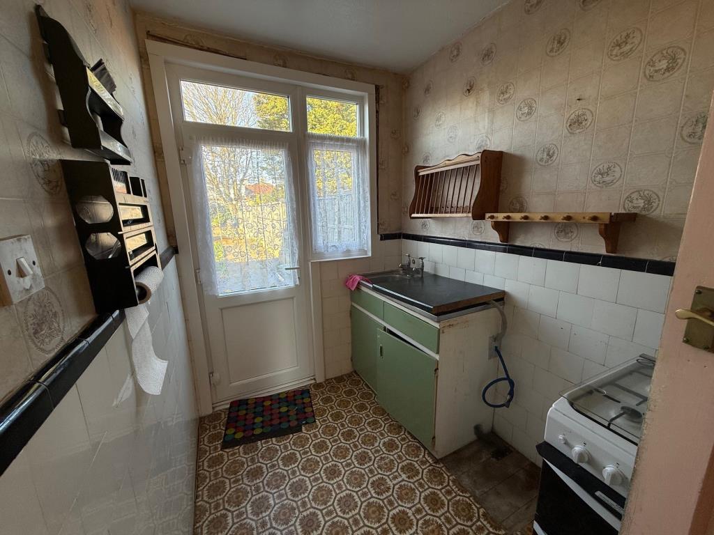 Lot: 109 - THREE-BEDROOM TERRACE HOUSE FOR IMPROVEMENT AND REFURBISHMENT - Kitchen area with door opening to rear garden